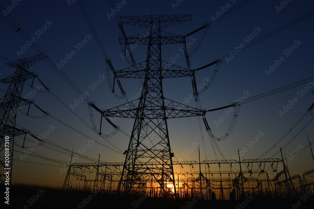 Fototapeta premium The silhouette of the evening electricity transmission pylon