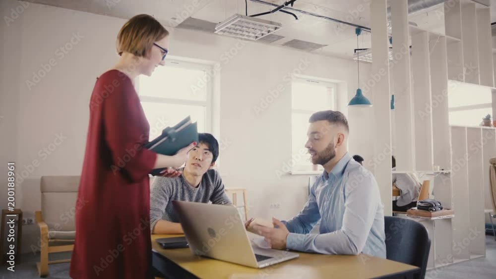 Camera follows attractive female boss enter office, talk to colleagues, smile, motivate workers in trendy office 4K. Camera follows attractive female boss enter office, talk to colleagues, smile, motivate workers in trendy office 4K.