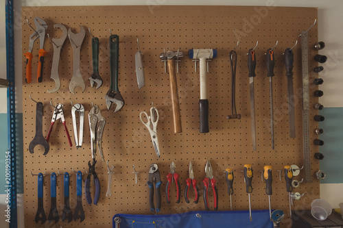 Work tools hanging on racks at bicycle repair shop photo