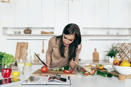 Fotografie Woman reading recipe simple summer salad cookbook simple healthy food