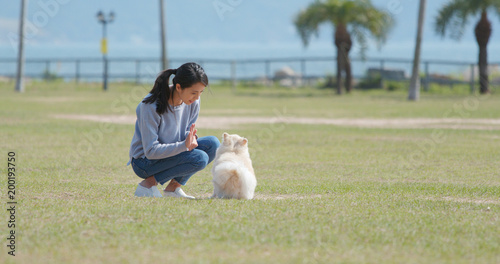 Woman training with her dog with snack at park