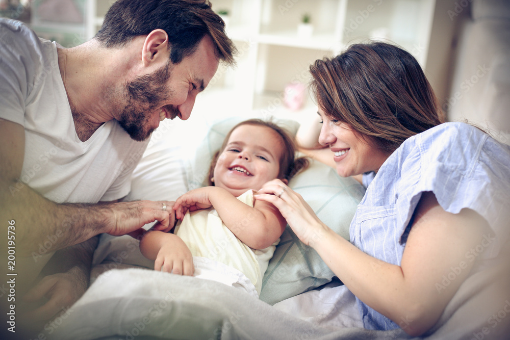 Parents playing with their daughter.