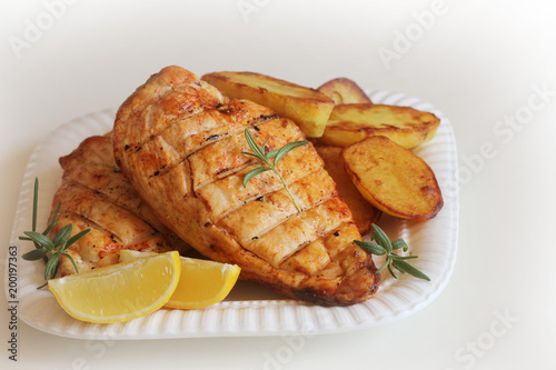 Grilled chicken breast with fried potato and lemon
