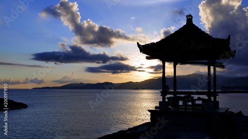 Sonnenuntergang am Meer in Candidasa Bali mit Pavillon als Silhouette