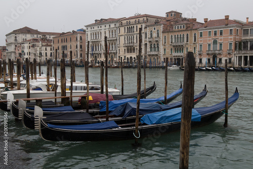 Parked covered gandolas on a pier in front of a water canal