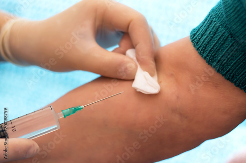 The doctor is preparing to make an intravenous injection