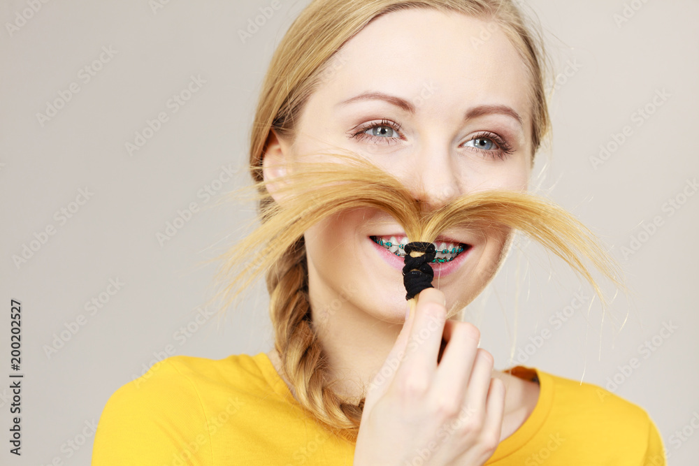Woman making moustache out of blonde hair