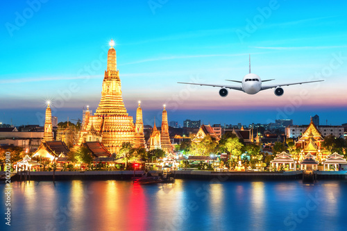 Airplane flying over Wat Arun  the Temple of Dawn  during sunset  Bangkok  Thailand