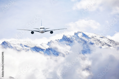 Fototapeta Naklejka Na Ścianę i Meble -  Airplane flying over snow mountains in winter