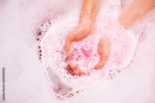 Fototapeta bath salt ball dissolves in the hands