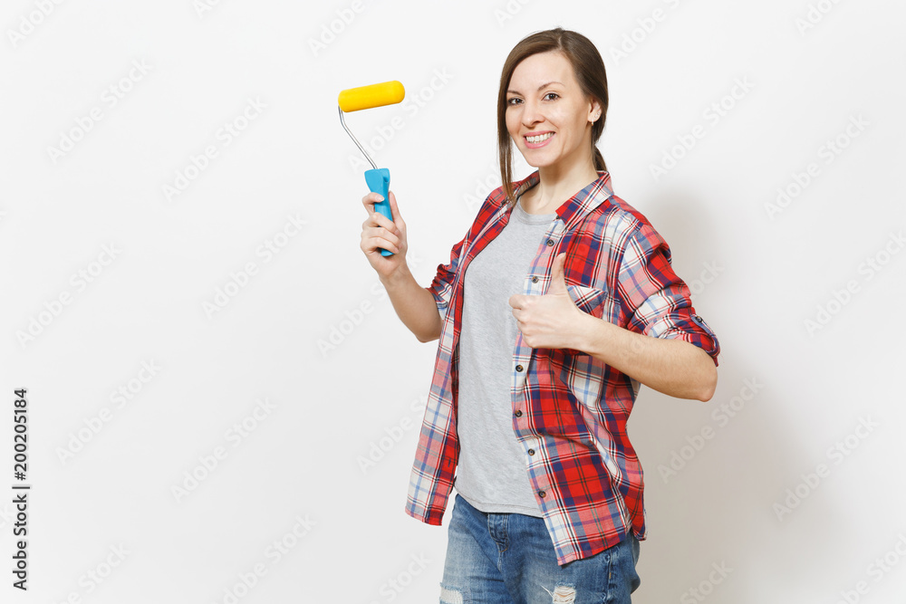 Young smiling beautiful woman holding paint roller for wall painting and showing thumb up isolated on white background. Instruments, accessories for renovation apartment room. Repair home concept. Young smiling beautiful woman holding paint roller for wall painting and showing thumb up isolated on white background. Instruments, accessories for renovation apartment room. Repair home concept.