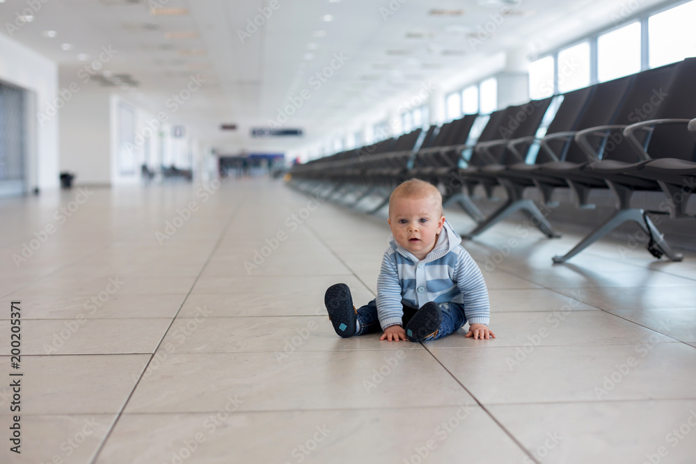 Obraz premium Little child, baby boy, playing at the airport, while waiting for his plane to departure