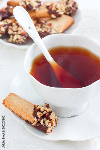 Cookies with nuts and chocolate and a cup of tea, selective focus photo