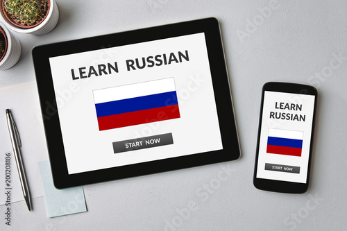 Learn Russian concept on tablet and smartphone screen over gray table. All screen content is designed by me. Flat lay