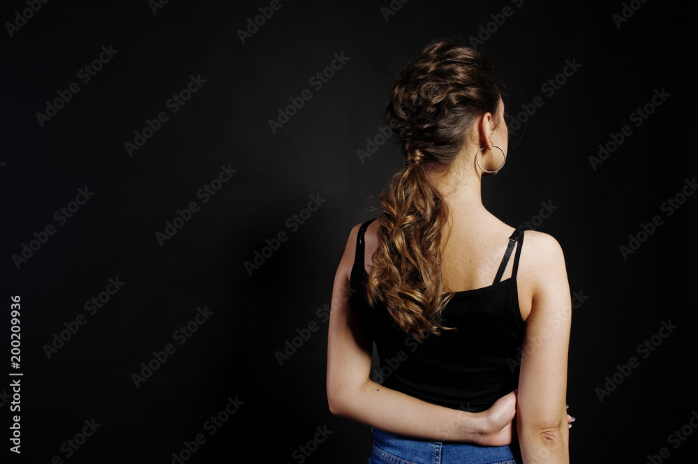 Studio portrait of back hairdress brunette girl on black background. Studio portrait of back hairdress brunette girl on black background.