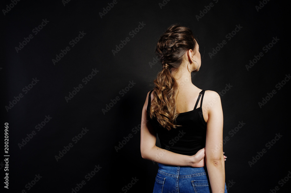 Studio portrait of back hairdress brunette girl on black background. Studio portrait of back hairdress brunette girl on black background.