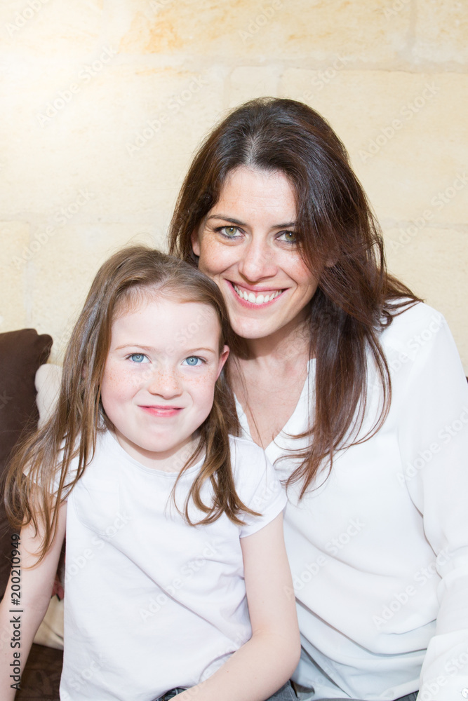 Smiling mother and daughter together in the living room sofa Smiling mother and daughter together in the living room sofa