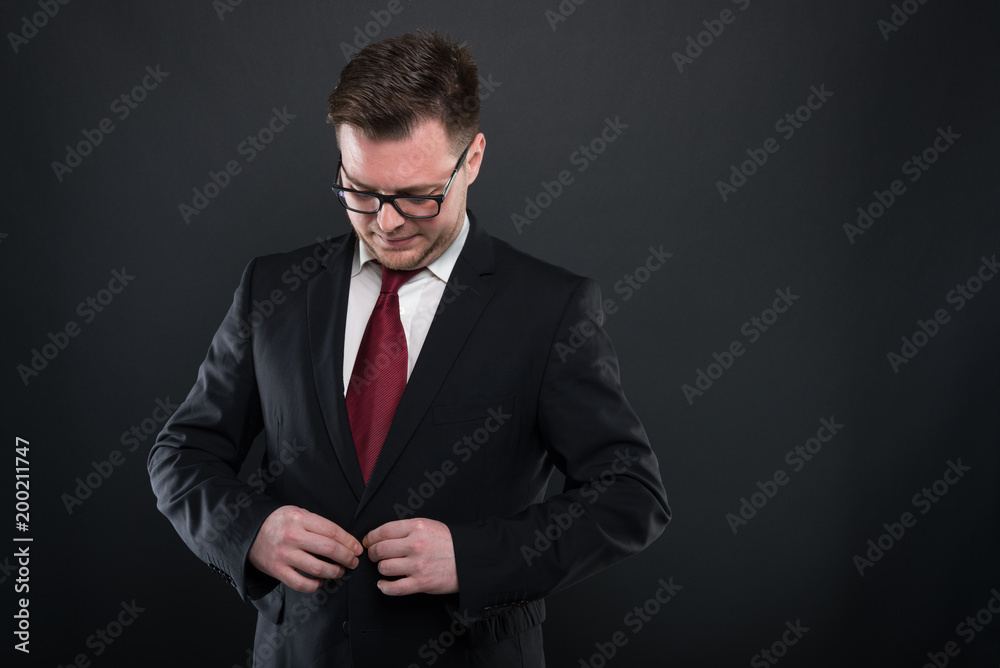 Portrait of business man wearing black suit buttoning jacket. Portrait of business man wearing black suit buttoning jacket.