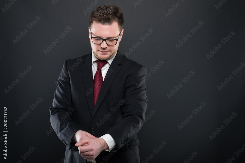 Portrait of business man wearing black suit arranging sleeve. Portrait of business man wearing black suit arranging sleeve.