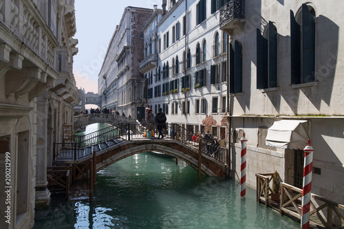Bridge with people across a narrow water canal between luxury residential buildings in Venice, Italy


 Venetian water with people on a bridge across water canal