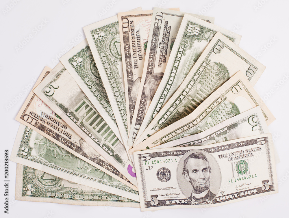 Pile of various US american dollar money bills spread on white background. Pile of various US american dollar money bills spread on white background.