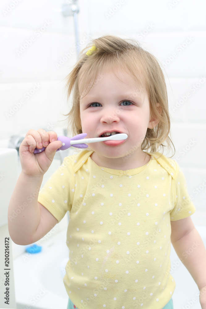 Cute little 2 years girl cleans teeth in bathroom Cute little 2 years girl cleans teeth in bathroom