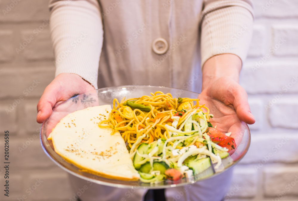 Egg omelette with pasta and vegetables on a transparent plate Egg omelette with pasta and vegetables on a transparent plate
