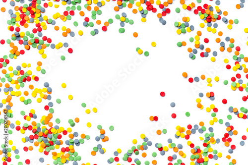 Colorful sweet confetti topping on white background with copy space at the center © Anastasiia Nurullina