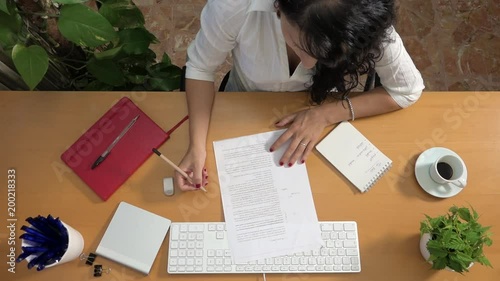 Businesswoman proofreading errors and omissions at office. Active caucasian woman reading draft text and deleting wrong content. Script revision of manager, company director correcting report