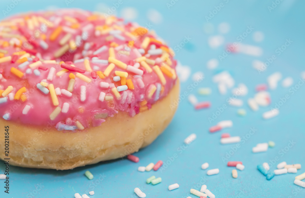 Pink donuts with sprinkles on blue background Pink donuts with sprinkles on blue background