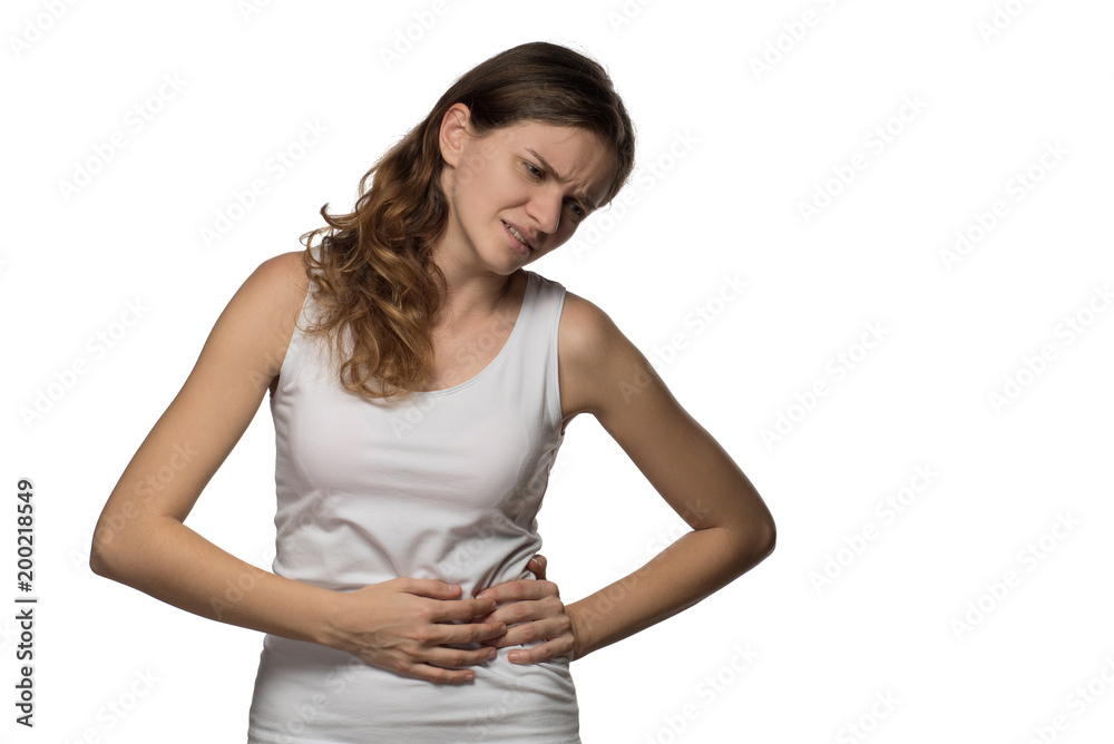 Pain and cramps in the abdomen of a beautiful girl on a white background Pain and cramps in the abdomen of a beautiful girl on a white background