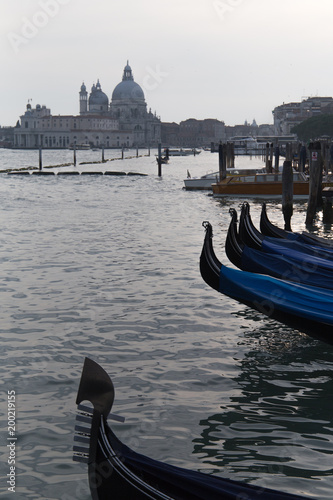 Parked gondolas on a pier with open sea lagoon view on Venice, Italy
