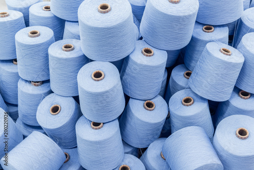 a large pile of spools of blue thread. close up