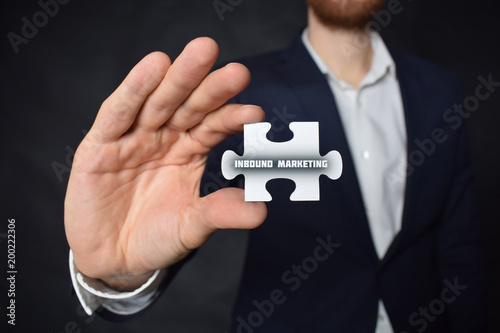 Businessman holding a puzzle with the inscription:INBOUND MARKETING