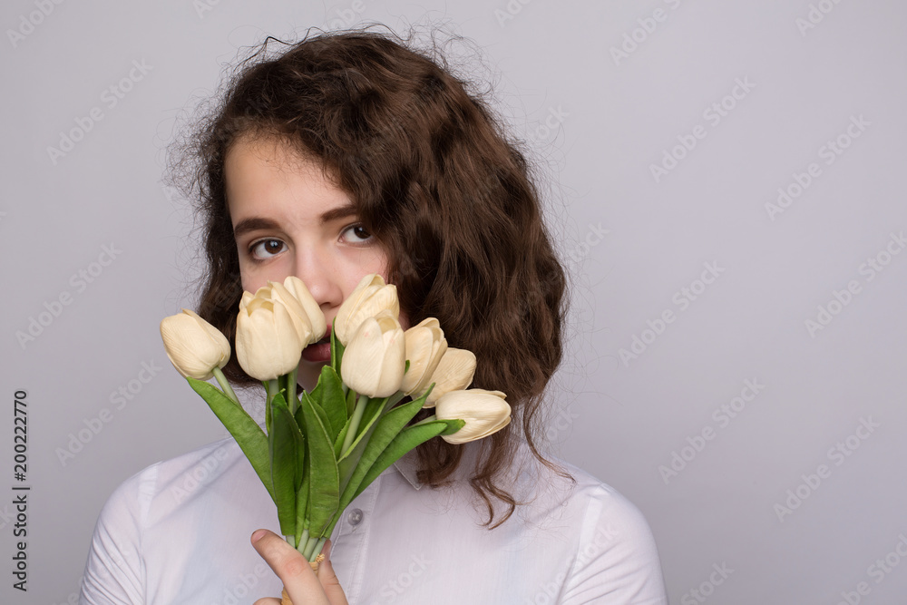 girl in a white blouse holding a bouquet of yellow and white tulips girl in a white blouse holding a bouquet of yellow and white tulips