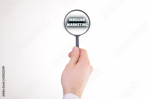 Businessman looking at a magnifying glass word:INBOUND MARKETING