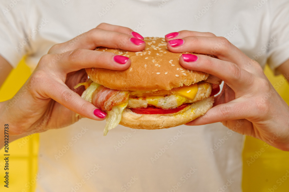 Seafood burger with shrimps holding in young woman hands