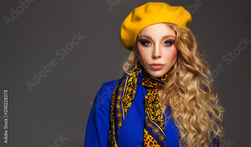 close-up. A beautiful girl with a professional make-up in a yellow beret and a blue jacket posing photo