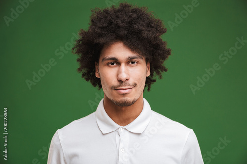 Handsome young curly man standing isolated