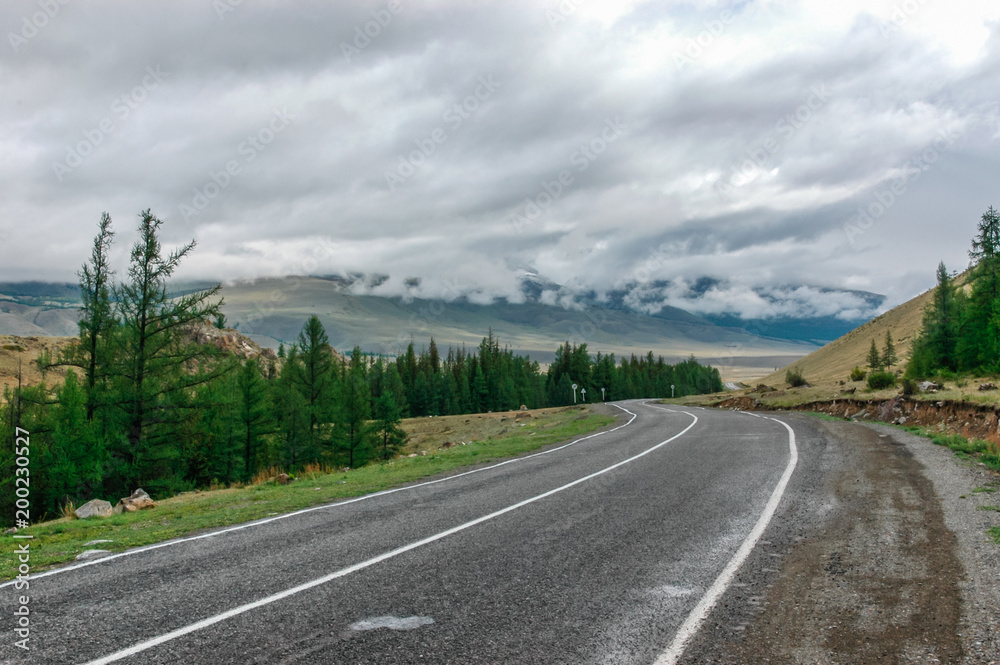 Mountain landscape with clouds. Mountain valley road. The Altai mountains. Travel adventure vacation background