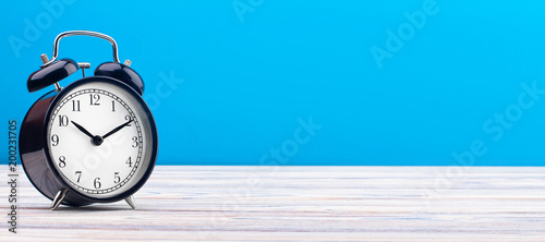 alarm clock wooden plank colored background