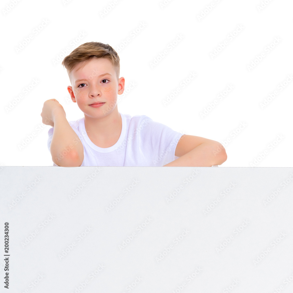 A boy of school age near a white advertising banner. A boy of school age near a white advertising banner.