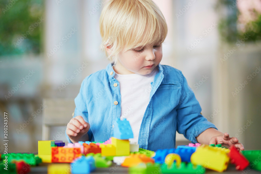 Little boy playing with colorful plastic construction blocks Little boy playing with colorful plastic construction blocks
