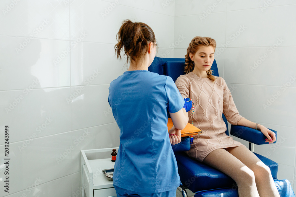 Foto de Doctor makes the patient an injection of a young woman. In the