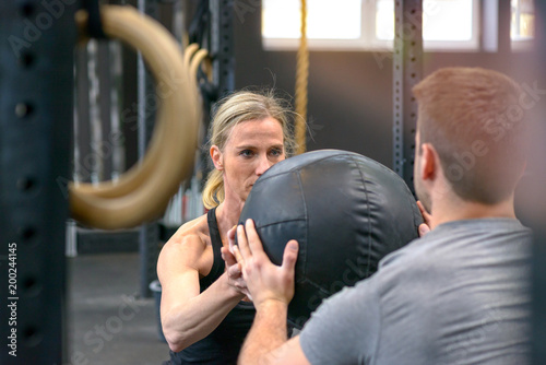 Man and woman working out with a medicine ball