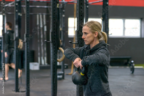 Strong fit woman lifting a kettle weight in a gym © michaelheim