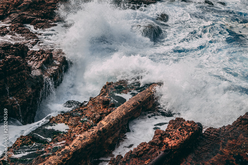 Waves in ocean crashing against rocks along the coast of Hermanus