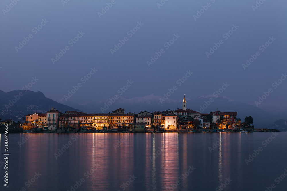 Reflections on the water by the lake at sunset. Fisherman Island, Lake Maggiore, Italy.
