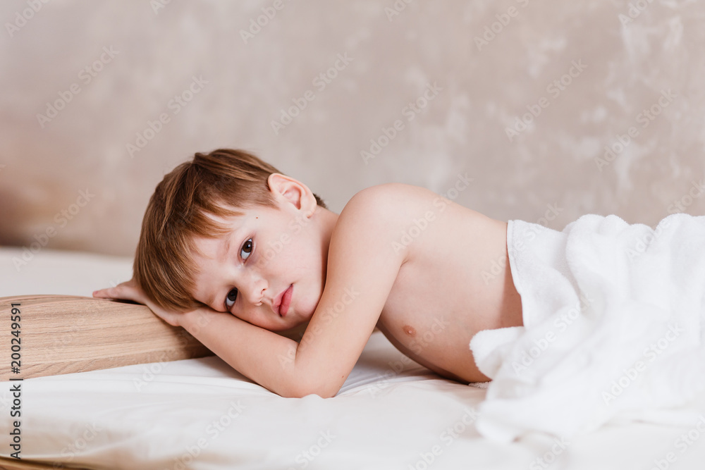 sad boy six years old lying on the bed sad boy six years old lying on the bed