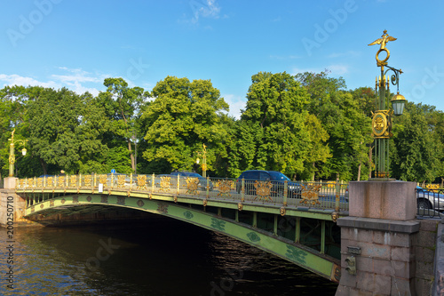 Saint Petersburg. The embankment of the Fontanka River and the Panteleymonovsky Bridge with lanterns decorated with gilded spears, shields and two-headed eagles on a summer sunny morning photo